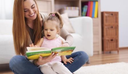 Mother showing images in book to her cute little girl